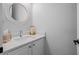 Compact powder room featuring a stylish round mirror and modern countertop with a sink at 1438 Stickley Ave, Celebration, FL 34747