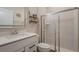 Cozy bathroom featuring a glass-enclosed shower and modern vanity with shelving at 14390 Orchid Island Dr, Orlando, FL 32827