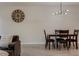 Bright dining area with modern light fixture and wood table that seats four, adjacent to the living room at 14390 Orchid Island Dr, Orlando, FL 32827