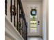 A view of the entryway featuring a staircase with black iron railings and a wreath-adorned front door at 14390 Orchid Island Dr, Orlando, FL 32827