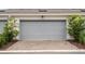 Attached garage with an attractive brick paver driveway lined with shrubs at 14390 Orchid Island Dr, Orlando, FL 32827