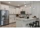 Modern kitchen with stainless steel appliances, white cabinets, and a breakfast bar at 14390 Orchid Island Dr, Orlando, FL 32827