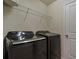 Laundry room equipped with modern black washer and dryer units, and storage shelf at 14390 Orchid Island Dr, Orlando, FL 32827