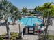 Beautiful community pool surrounded by palm trees, lounge chairs, and umbrellas at 14390 Orchid Island Dr, Orlando, FL 32827