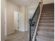 A view of an open staircase, with a wrought iron railing and entry hallway with wood-look tile at 14390 Orchid Island Dr, Orlando, FL 32827