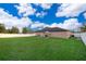 Backyard featuring green grass and a white fence on a sunny day at 146 Hidden Pointe Ln, Groveland, FL 34736
