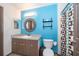 Stylish bathroom featuring blue walls, vanity with sink, round mirror, and a toilet at 146 Hidden Pointe Ln, Groveland, FL 34736
