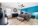 Primary bedroom with blue accent wall, a ceiling fan and well-lit windows at 146 Hidden Pointe Ln, Groveland, FL 34736