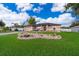 Front yard featuring a meticulously designed rock garden and lush green lawn at 146 Hidden Pointe Ln, Groveland, FL 34736