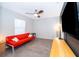Cozy living room with stylish red futon sofa and a large screen TV at 146 Hidden Pointe Ln, Groveland, FL 34736