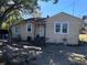 Charming bungalow-style home featuring a partially fenced yard, mature trees, and a covered parking area at 1500 43Rd St, Orlando, FL 32839
