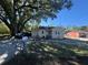 Charming bungalow-style home featuring a partially fenced yard and mature trees under a blue sky at 1500 43Rd St, Orlando, FL 32839