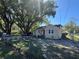 Charming bungalow-style home featuring a partially fenced yard and mature trees under a clear sky at 1500 43Rd St, Orlando, FL 32839