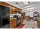 Kitchen with wooden cabinets, black appliances, tile flooring, open to the dining area at 1588 Alloway Dr, Deltona, FL 32738