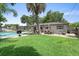 Backyard featuring a pool, grass area, seating, and mature trees at 2020 Geronimo Trl, Maitland, FL 32751