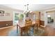 Traditional dining room with wooden table and chairs, chandelier, and view of pool through sliding glass door at 2020 Geronimo Trl, Maitland, FL 32751