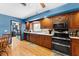 Well-lit kitchen featuring dark wooden cabinets, modern appliances, and a view into the laundry room at 2020 Geronimo Trl, Maitland, FL 32751
