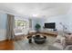 Bright living room with neutral furniture, hardwood floors, and a large window that fills the space with light at 2020 Geronimo Trl, Maitland, FL 32751