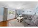 Bright living room featuring light blue walls, a gray sectional, and large window letting in natural light at 2020 Geronimo Trl, Maitland, FL 32751