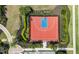 Aerial view of a red and blue outdoor basketball court with manicured landscaping surrounding the court at 2171 Timber Creek Ln, Clermont, FL 34715