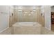 Luxurious bathroom featuring a soaking tub and separate glass-enclosed shower with dual shower heads at 2171 Timber Creek Ln, Clermont, FL 34715