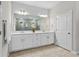 Bathroom featuring a dual vanity with modern fixtures, a large mirror, and tiled floors at 2171 Timber Creek Ln, Clermont, FL 34715