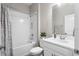 Well-lit bathroom featuring a shower-tub combo with white tiles, a vanity, and modern fixtures at 2171 Timber Creek Ln, Clermont, FL 34715