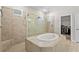Bathroom with soaking tub, walk-in shower, and access to a closet space at 2171 Timber Creek Ln, Clermont, FL 34715