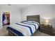 Cozy bedroom featuring a striped comforter, gray headboard, and a closet filled with plush toys at 2171 Timber Creek Ln, Clermont, FL 34715