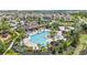 Aerial view of a resort-style community pool with palm trees, lounge chairs, and lush landscaping at 2171 Timber Creek Ln, Clermont, FL 34715