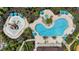 Overhead view of a community pool with water features, umbrellas and lounge chairs, surrounded by landscaping at 2171 Timber Creek Ln, Clermont, FL 34715