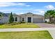 Beautiful single-story home boasts a lush lawn, landscaped beds, and a two-car garage with brick-paved driveway at 2171 Timber Creek Ln, Clermont, FL 34715