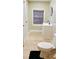 Bathroom featuring light laminate flooring, sink, toilet, and a closed window with wood blinds at 238 Lake Dr, Orlando, FL 32835