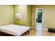 Bedroom with green walls, wood floors, and a door leading to the exterior, featuring a bed and microwave at 238 Lake Dr, Orlando, FL 32835