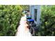 Exterior side yard with trash cans along a narrow walkway with brick accents and green landscaping at 238 Lake Dr, Orlando, FL 32835