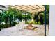Outdoor patio area with shade structure, brick trim, and lush landscaping and a stone tile floor at 238 Lake Dr, Orlando, FL 32835