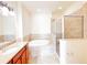 Bright bathroom features a soaking tub, glass enclosed shower, and vanity with granite countertop at 2520 Bella Vista Dr, Davenport, FL 33897