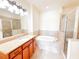 Bright bathroom features a soaking tub, glass enclosed shower, and vanity with granite countertop at 2520 Bella Vista Dr, Davenport, FL 33897