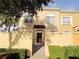 Charming townhome with tan exterior, red tile accents, walkway, and lush landscaping offering a cozy and inviting curb appeal at 2520 Bella Vista Dr, Davenport, FL 33897