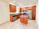 A kitchen with stainless steel appliances, granite countertops, tile flooring, and wood cabinets at 2520 Bella Vista Dr, Davenport, FL 33897