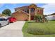 Charming two-story home featuring a well-manicured lawn and a welcoming front entrance with stone-edged garden at 314 Edgewood Ct, Kissimmee, FL 34759