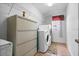 Functional laundry area with washer, dryer, and shelving for storage at 314 Edgewood Ct, Kissimmee, FL 34759
