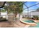 Relaxing pool area featuring a jacuzzi, dining table, and screened in patio at 314 Edgewood Ct, Kissimmee, FL 34759