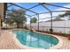 Inviting screened pool area featuring a sparkling pool with a waterfall, perfect for relaxation and outdoor enjoyment at 314 Edgewood Ct, Kissimmee, FL 34759