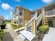 A bright yellow condo with white trim, stairs, and manicured landscaping at 3142 Britannia Blvd # C, Kissimmee, FL 34747