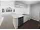 Well-lit kitchen with stainless steel dishwasher, white cabinets, and dark wood flooring at 3142 Britannia Blvd # C, Kissimmee, FL 34747