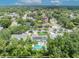 Aerial view of the home featuring a pool, solar panels, mature trees, and nearby homes at 320 Bridle Path, Casselberry, FL 32707