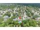 Aerial view of a house with solar panels and a private backyard pool surrounded by lush green trees in a quiet neighborhood at 320 Bridle Path, Casselberry, FL 32707