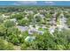 Aerial view of a house with solar panels and a private backyard pool surrounded by lush green trees in a quiet neighborhood at 320 Bridle Path, Casselberry, FL 32707