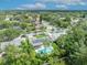 Aerial view of a house with solar panels and a private backyard pool surrounded by lush green trees in a quiet neighborhood at 320 Bridle Path, Casselberry, FL 32707